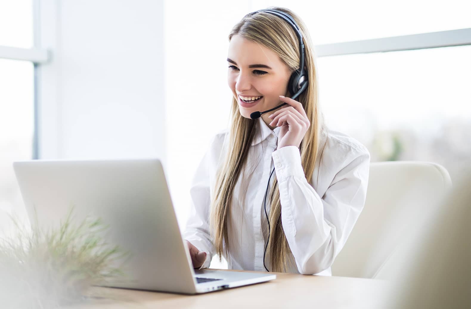 Frau in weißer Bluse mit Headset